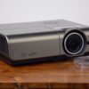 Professional high-brightness DLP projector rental unit with lens cap beside it, available for Vancouver events