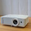 Optoma 5000 lumen Full HD projector rental unit for bright event spaces, displayed on a wooden surface