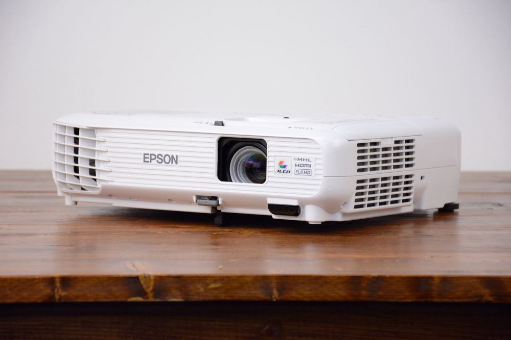 1080p-Epson-projector-rental Compact Epson Full HD projector available for rental in Vancouver, displayed on a rustic wood table