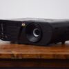 1080p black projector rental for Vancouver events, shown from the front-side angle on a rustic wood table