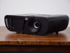 1080p black projector rental for Vancouver events, shown from the front-side angle on a rustic wood table