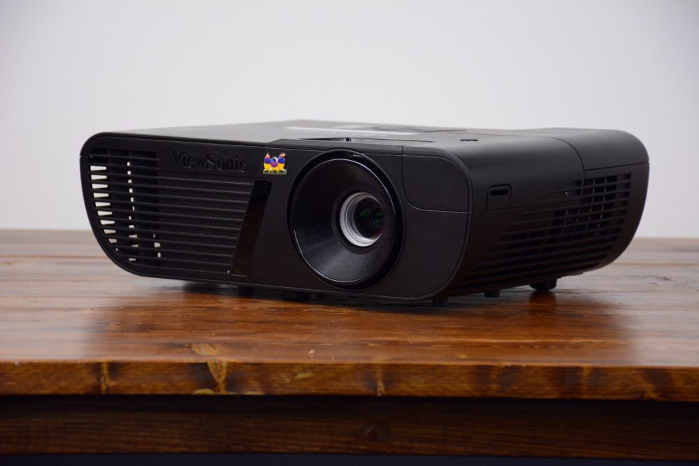1080p black projector rental for Vancouver events, shown from the front-side angle on a rustic wood table