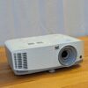 Most-affordable-projector-screen-rental ViewSonic DLP projector rental unit shown from the front with lens and ventilation grille on a wooden surface