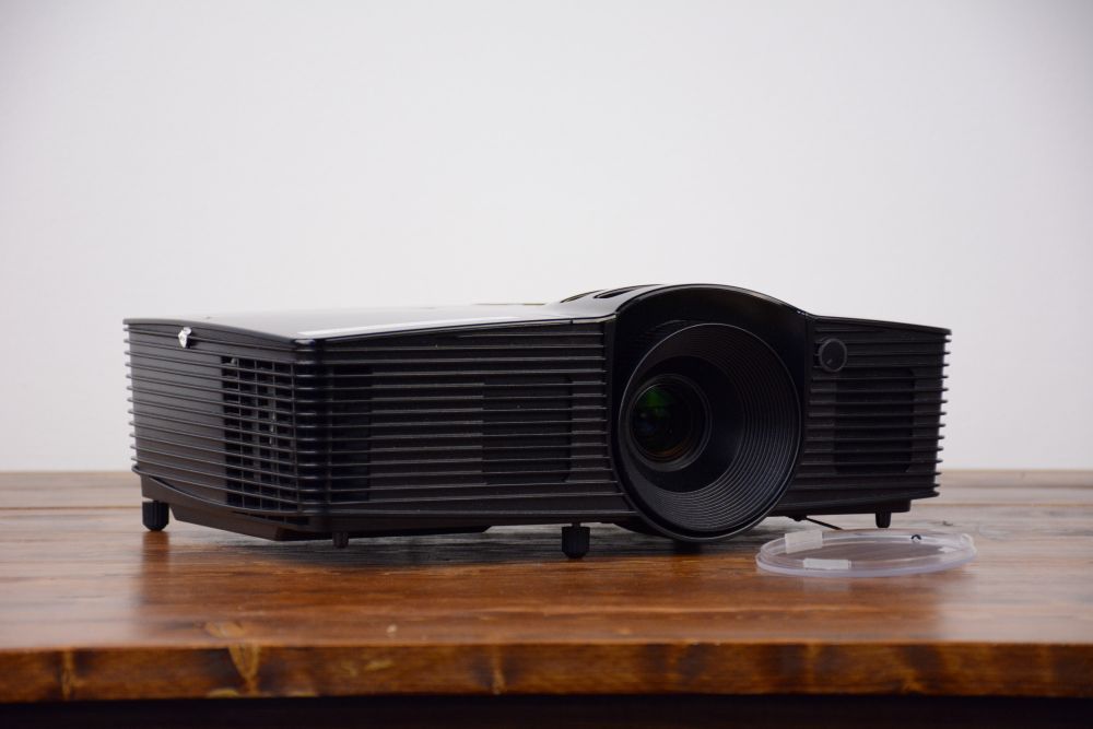 Vancouver-1080p-video-projector-rental Compact black video projector rental with lens cap beside it, available for events in Vancouver
