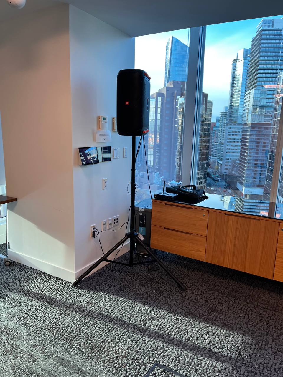 JBL speaker on a tripod stand with a wireless microphone system set up in a Vancouver high-rise corporate event room