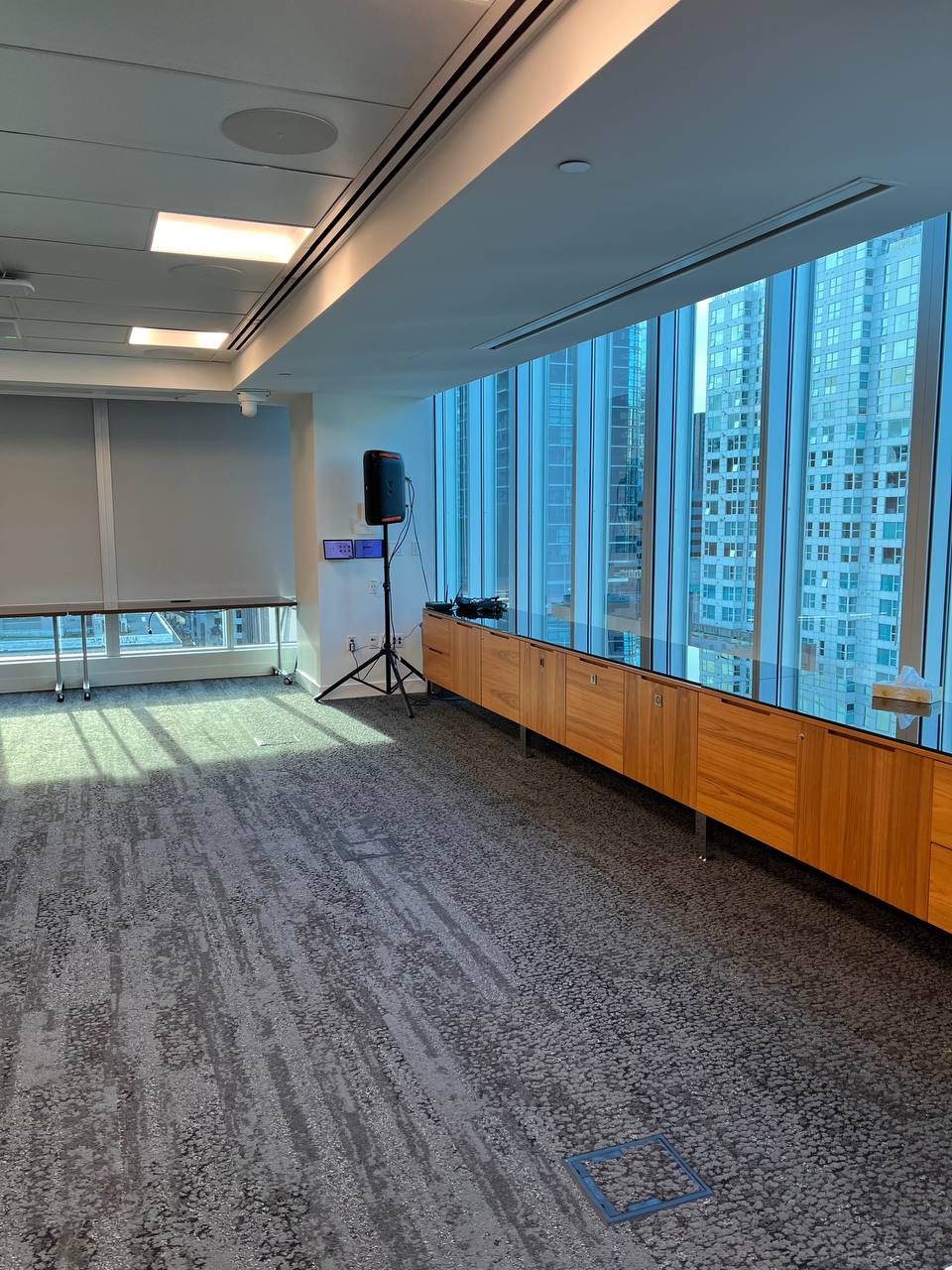 JBL speaker rental on a tripod stand positioned next to a PwC pull-up banner in a Vancouver high-rise corporate venue