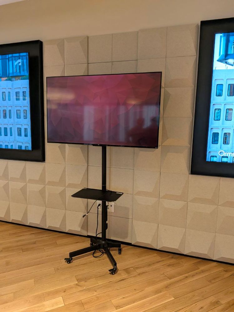 Professional TV and stand rental positioned against an acoustic panel wall in a Vancouver downtown business event room