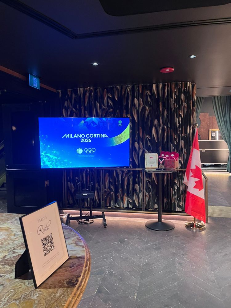 TV rental setup at Prophecy Cocktail Bar Vancouver showing Milano Cortina 2026 Olympic Games broadcast with Canadian flag display