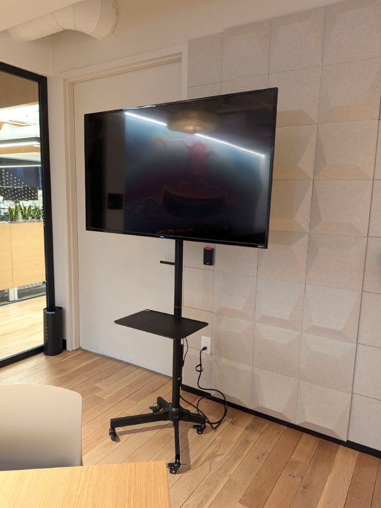 Professional TV and wheeled stand rental ready for a business presentation in a contemporary downtown Vancouver office room