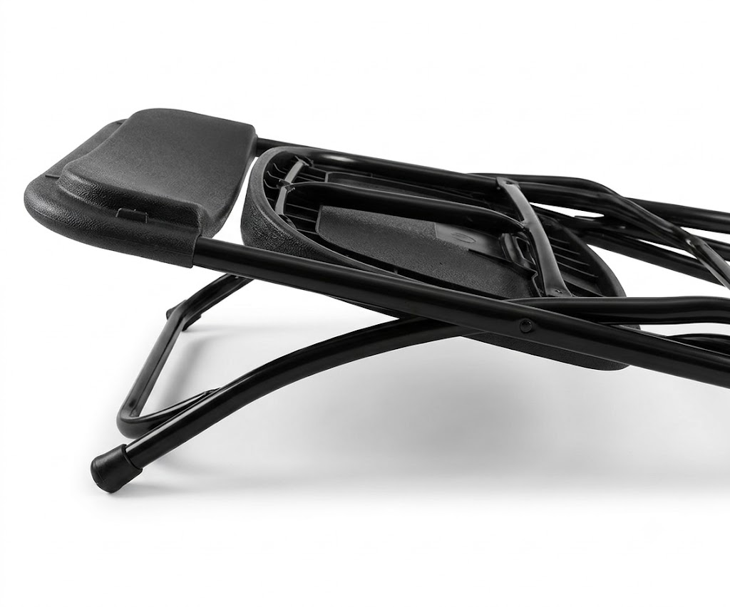 Black Folding Chair Folded Position Angle View Angled close-up of a black folding chair in its folded position showing the metal frame and plastic seat and back