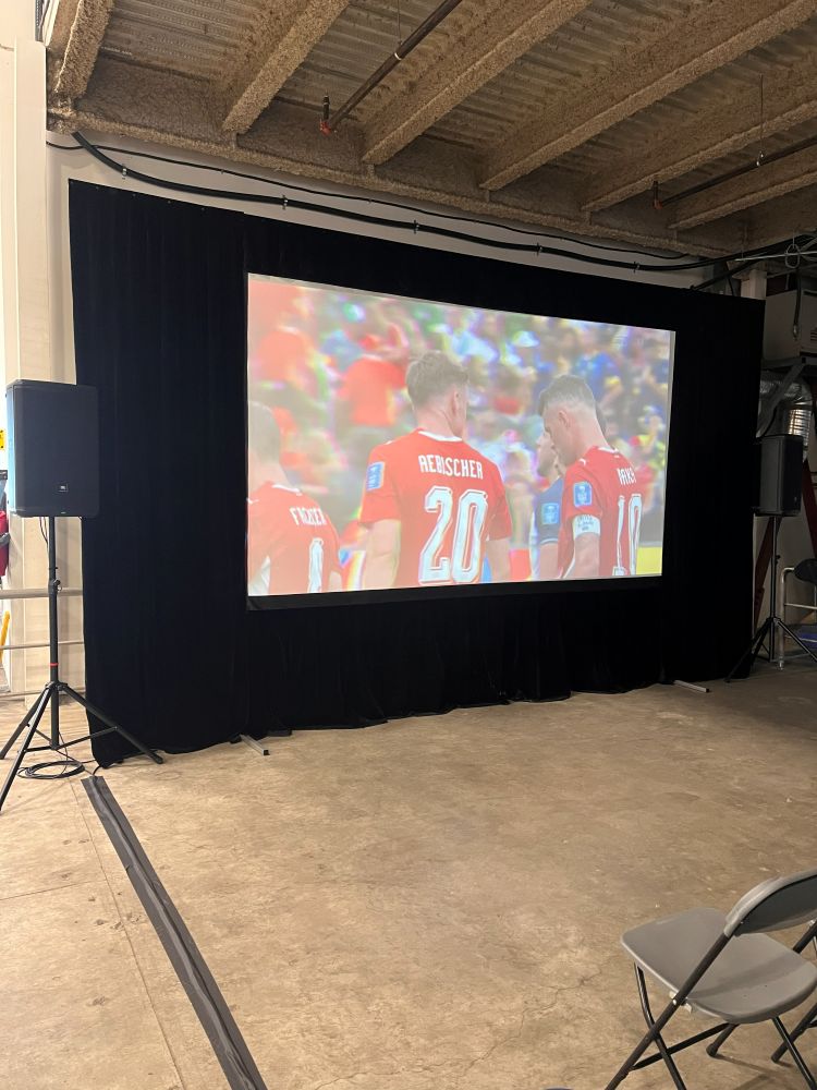 FIFA World Cup watch party setup with a large fast-fold screen rental, black drape surround, and JBL speaker rentals in a Maple Ridge venue