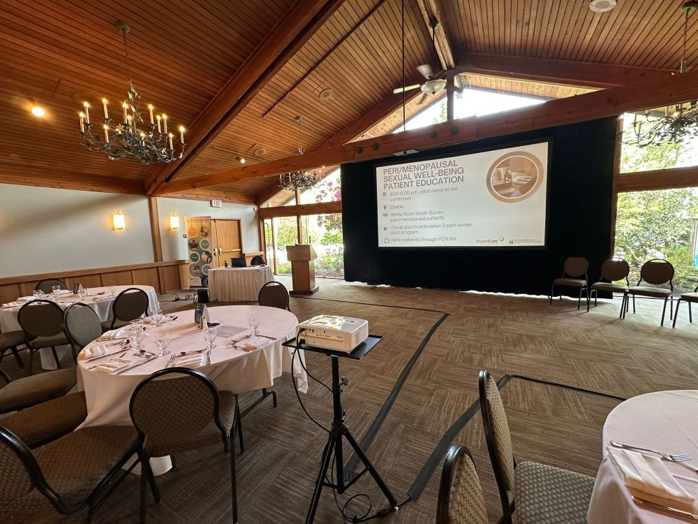 Large projection screen and projector rental at a Surrey golf course venue, with round dining tables set for a medical education dinner event