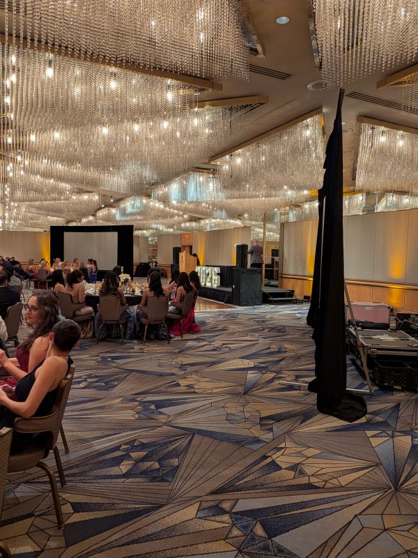 Wide view of the Pan Pacific ballroom showing rear-projected screens and truss-mounted 8,000-lumen projectors during a school prom