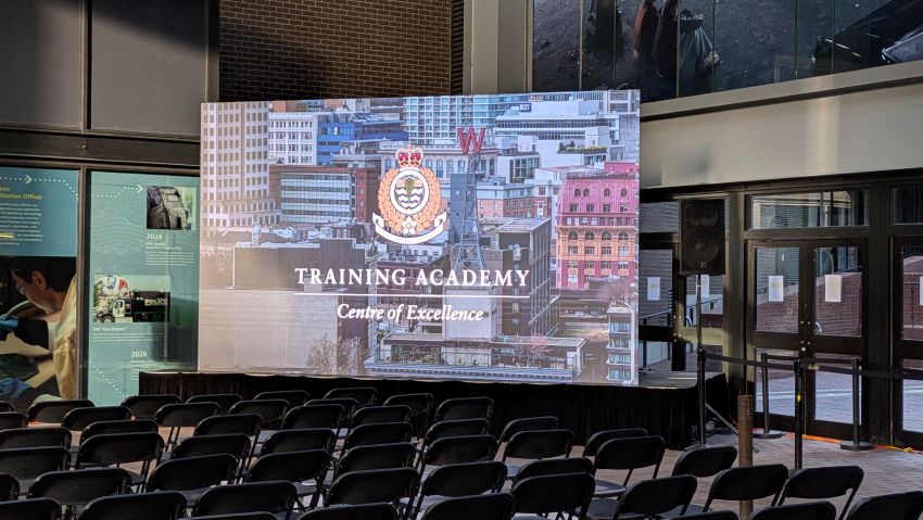 LED wall with Training Academy branding facing rows of seating for 200+ guests