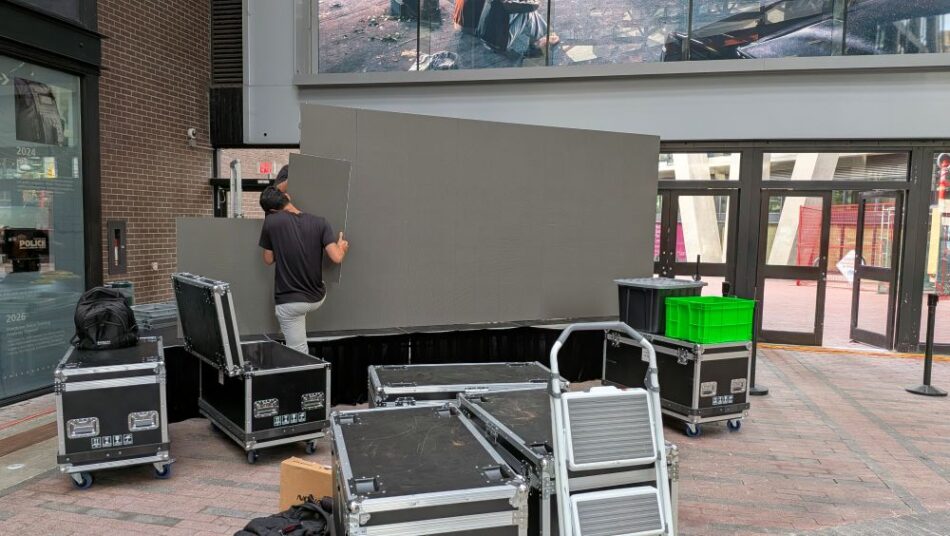 Vancouver Projector Rentals crew assembling P2.9 LED wall panels with road cases in the atrium
